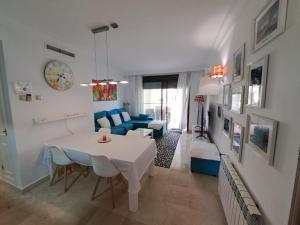 - un salon avec une table blanche et un canapé bleu dans l'établissement Roda Golf gelijkvloers appartement, à Roda