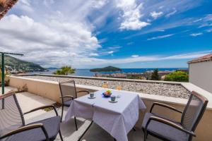 una mesa y sillas en un balcón con vistas al océano en Apartment Viki, en Dubrovnik