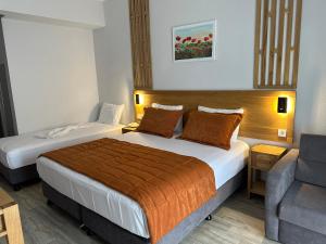 ein Hotelzimmer mit zwei Betten und einer Couch in der Unterkunft Hotel Panaya in Gokceada Town