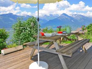 韋松納的住宿－Chalet CNY01，甲板上配有带遮阳伞的木制野餐桌