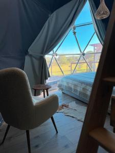 Pokój z krzesłem, łóżkiem i oknem w obiekcie Sëtnowa Glamping w mieście Sitno