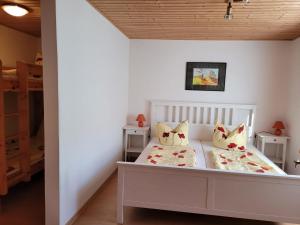 a bedroom with a white bed with two pillows at Ferienwohnung 500m zum See in Vollrathsruhe