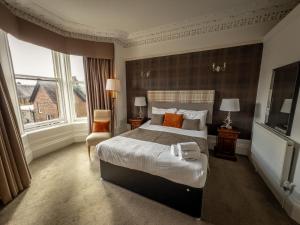 a bedroom with a large bed and a large window at The Crags Hotel in Callander