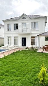 una gran casa blanca con un gran patio en White villa 4 bedrooms, en Gabala