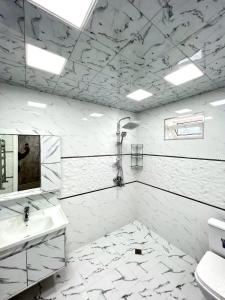 Un baño blanco con lavabo y ducha. en White villa 4 bedrooms, en Gabala