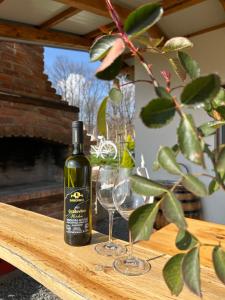 a bottle of wine and two glasses on a table at Kuća za odmor Baron in Kutjevo