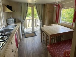 a small kitchen with a table and a counter top at Camping La sablière in Saint-Jans-Cappel