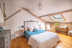 a bedroom with a bed and a dresser and a window at La Grange des Anges in Blanc