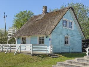 uma antiga casa azul com telhado de palha em Kolorowe Domki nad Narie em Pojezierce