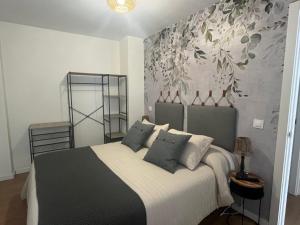 1 dormitorio con 1 cama con almohadas blancas y negras en Apartamentos Sierra, en Ezcaray