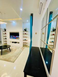 TV a/nebo společenská místnost v ubytování Central Oasis - Entire 3 Bedroom Apartment in Abuja with Pool, Games, WiFi, Balcony, and Garden