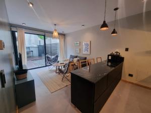 Una sala de estar con cocina y comedor. en Dolomite 2 - Andarlibre, en San Martín de los Andes