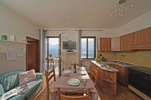 een keuken en een woonkamer met een tafel en een bank bij Maison du Pralonc - Cielo in Tremosine Sul Garda