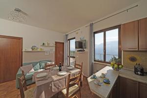 een keuken en een woonkamer met een tafel en een eetkamer bij Maison du Pralonc - Cielo in Tremosine Sul Garda