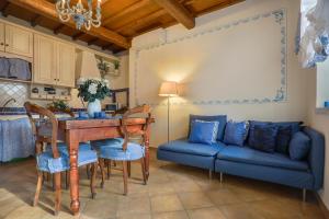 un soggiorno con tavolo e divano blu di MIRTILLO di Home Hill a Lucca