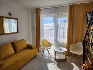 a living room with a couch and a window at Twój Port in Krynica Morska