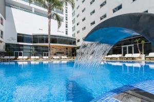 una fuente en una piscina en un edificio en VS Gandía Palace Hotel ****, en Gandía