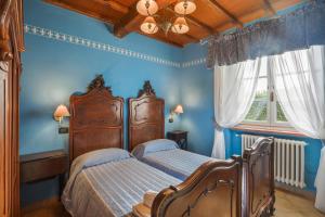 - une chambre bleue avec 2 lits et une fenêtre dans l'établissement MIRTILLO di Home Hill, à Lucques