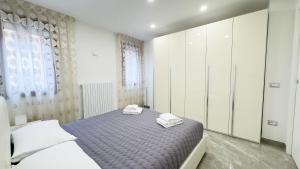 a bedroom with a bed with two towels on it at Casa Venturini by Ca-Sa Check in Chioggia +38 photos