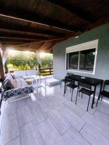 a patio with a table and chairs and a couch at Chalkidiki Beach House in Nea Potidaea