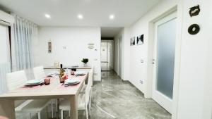 a white dining room with white tables and white chairs at Casa Venturini by Ca-Sa Check in Chioggia