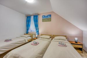 three beds in a room with a window at Rooms Centar in Delnice