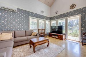 a living room with a couch and a tv at Holiday Cabin Mäntyhovi in Kalajoki