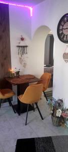 ピエシュチャニにあるUbytovanie Danaのテーブル、椅子、時計が備わる客室です。