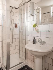 een witte badkamer met een wastafel en een douche bij Hôtel Basss in Parijs