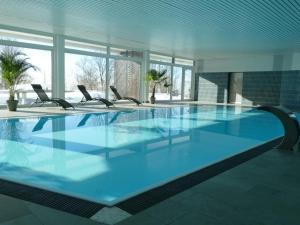 Inviting apartment in Freyung with sauna indoor pool في فرايونغ: مسبح كبير مع كراسي في مبنى
