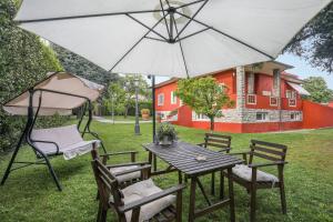 - une table et des chaises avec un parasol dans la cour dans l'établissement MIRTILLO di Home Hill, à Lucques