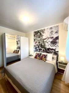 a bedroom with a bed with a flower mural on the wall at Apartments Villa Viktoria in Tivat
