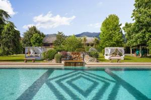 una piscina con due sedie e una casa di MIRTILLO di Home Hill a Lucca
