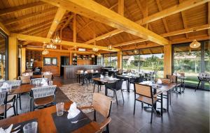 un restaurante con techos de madera, mesas y sillas en 3 Bedroom Gorgeous Home In Bilje, en Bilje