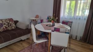 salon ze stołem, krzesłami i kanapą w obiekcie Salt Orchid Apartments w mieście Turda