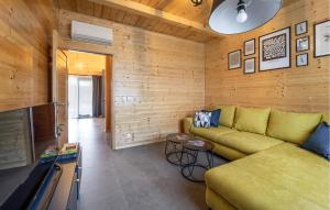 a living room with a green couch and wooden walls at 3 Bedroom Gorgeous Home In Bilje in Bilje