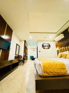 um quarto de hotel com uma cama e uma secretária em Bling International Hotel Multan em Multan