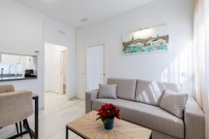 una sala de estar con un sofá y una mesa en APARTAMENTOS FIBES GARDEN SEVILLA, en Sevilla