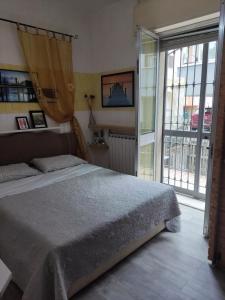 a bedroom with a bed and a large window at Villetta orchidea in Rimini