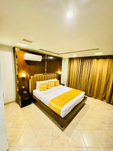 um quarto com uma cama grande com lençóis amarelos em Bling International Hotel Multan em Multan