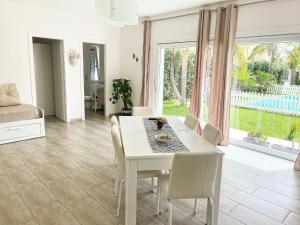 a white dining room with a table and chairs at Angolo paradiso in Castelvetrano Selinunte