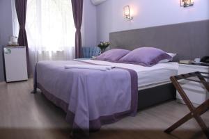 een slaapkamer met een groot bed met paarse dekens en kussens bij A Hotels & Suite in Ankara