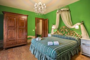 um quarto com uma cama com paredes verdes e um lustre em BASILICO di Home Hill em Capannori