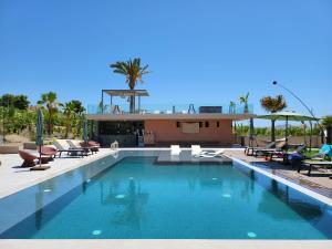 una gran piscina con sillas y una casa en Terreforti Luxury Village, en Agrigento