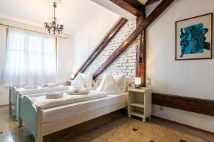 a bedroom with two beds and a brick wall at Best Western Hotel Strasser in Graz