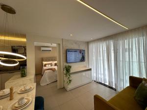 a living room with a bed and a large window at Altamare - Pé na areia in Tambaú