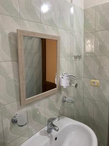y baño con lavabo y espejo. en Vila Haznedari en Berat