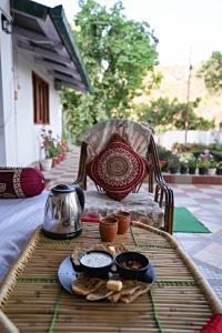 una mesa con una bandeja de comida en una mesa en Nature's Vibe Homestay - Nainital - Kainchi Dham, en Nainital