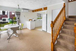 a kitchen and dining room with a table and a staircase at Big sale in winter three bedrooms two bathrooms in karori in Wellington