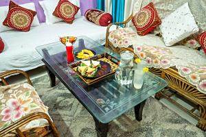 Nature's Vibe Homestay - Nainital - Kainchi Dham في ناينيتال: طاولة قهوة مع صينية طعام على أريكة